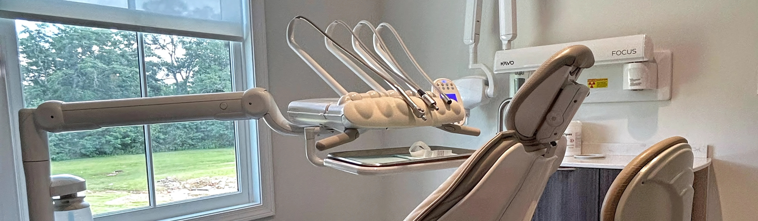 A dental professional in protective gear prepares a patient for a 3D dental X-ray scan using specialized equipment - North Atlanta Family Dentistry