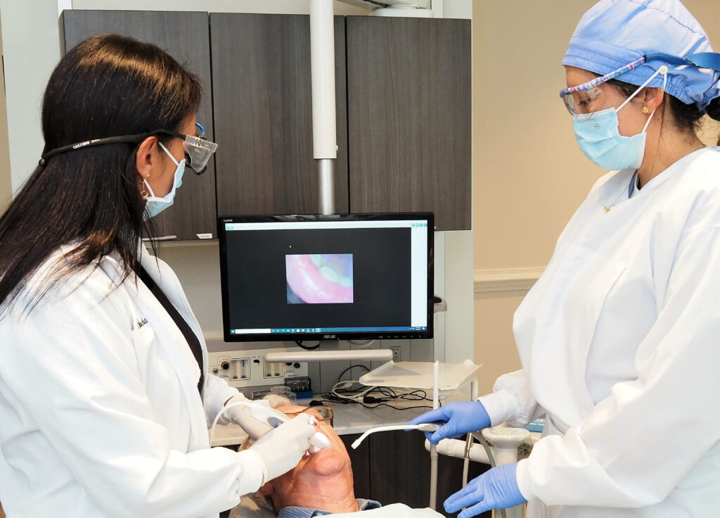 Dr. Sandra L. Vargas DMD, DDS of North Atlanta Family Dentistry together with her dental assistant is examining a patient's mouth - North Atlanta Family Dentistry Dr. Sandra L. Vargas DMD, DDS of North Atlanta Family Dentistry together with her dental assistant is examining a patient's mouth - North Atlanta Family Dentistry