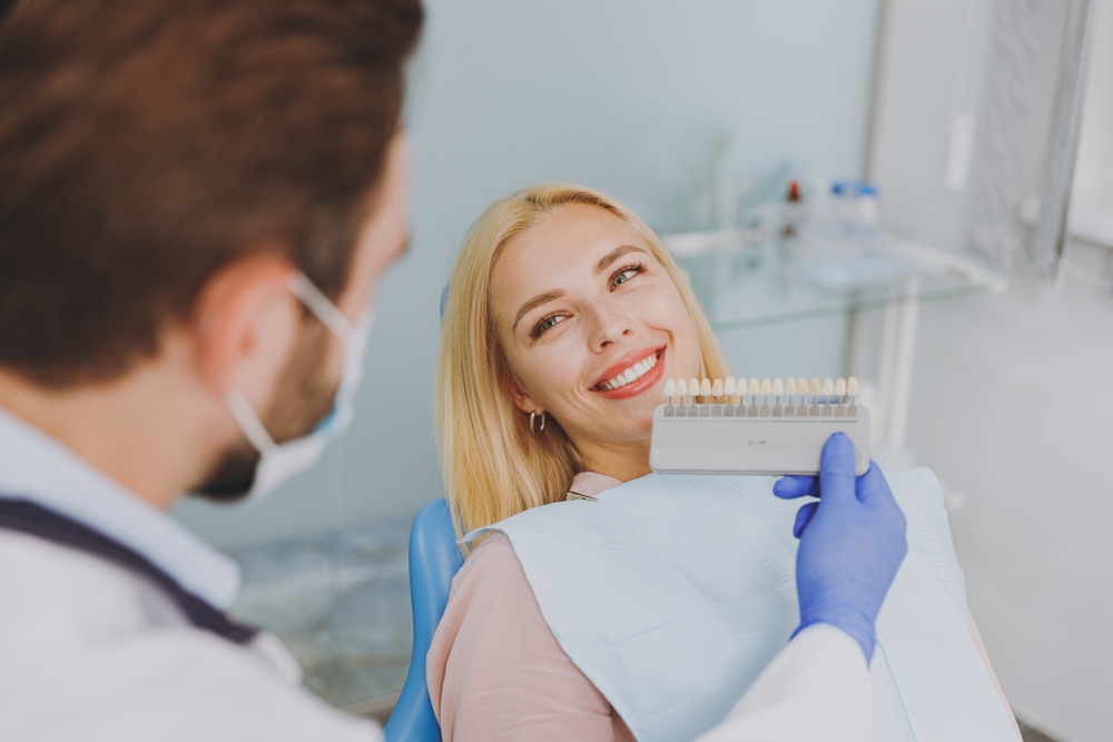 dentist showing tooth color scale to patient