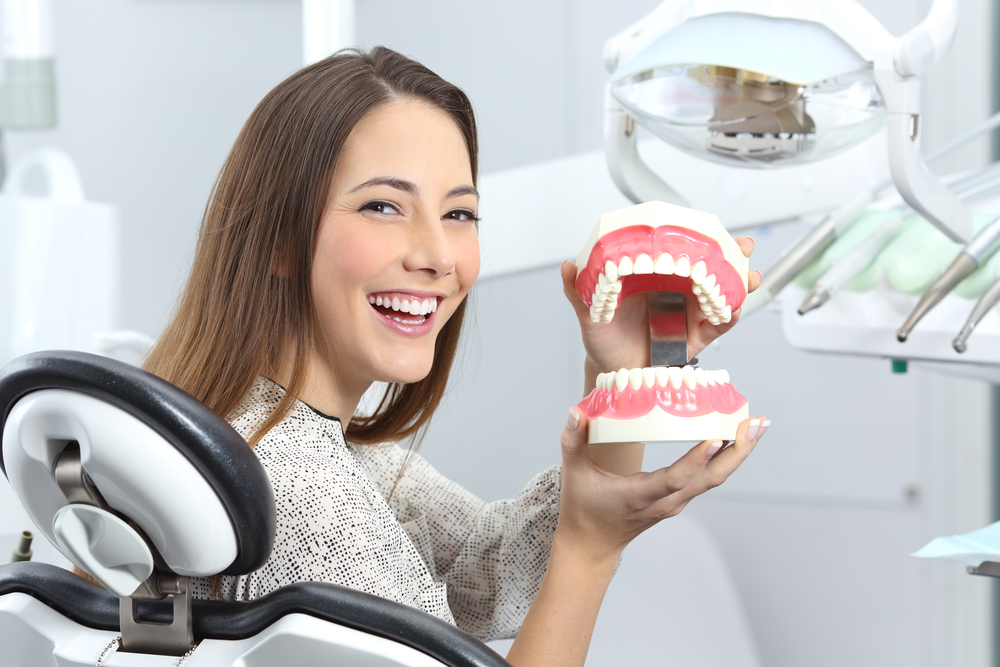 dental patient holding a teeth model - Dentures in Cumming