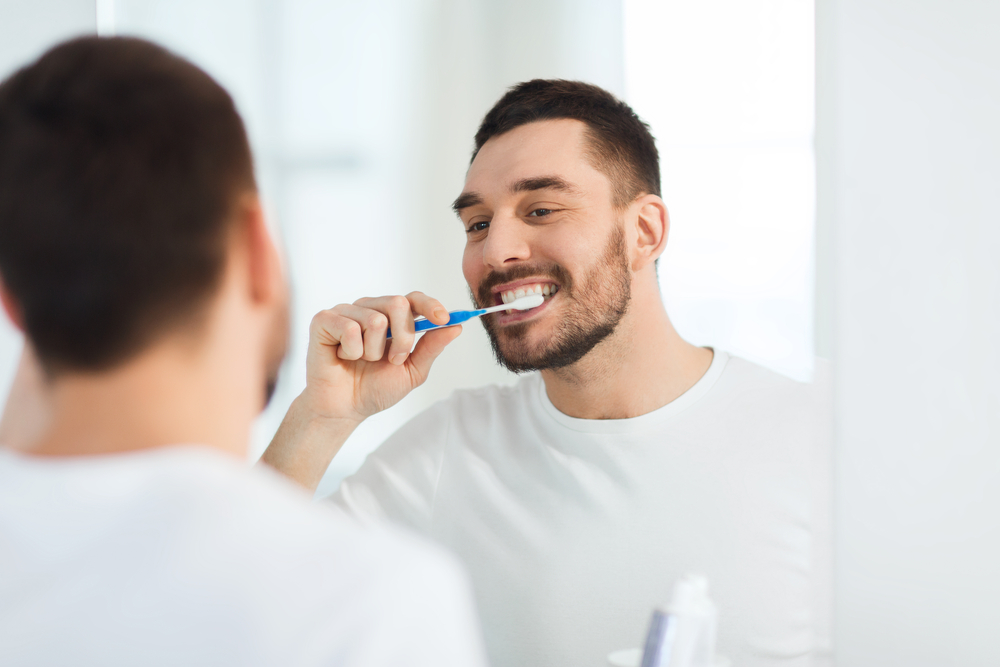 bearded man brushing his teeth