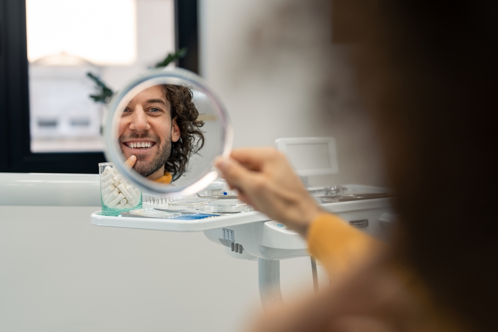 curly-haired man looking at the mirror