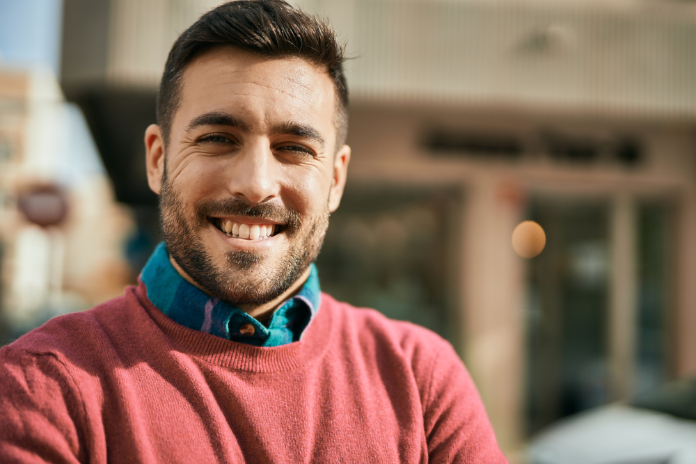a man posing outdoors in the sun