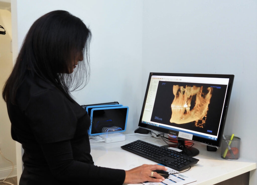 Dr. Sandra L. Vargas DMD, DDS of North Atlanta Family Dentistry is analyzing a scan result of a patient's dental structure on a monitor - North Atlanta Family Dentistry Dr. Sandra L. Vargas DMD, DDS of North Atlanta Family Dentistry is analyzing a scan result of a patient's dental structure on a monitor - North Atlanta Family Dentistry